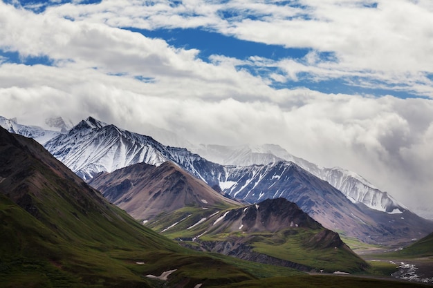 Montanhas pitorescas do Alasca no verão. Maciços cobertos de neve, geleiras e picos rochosos.