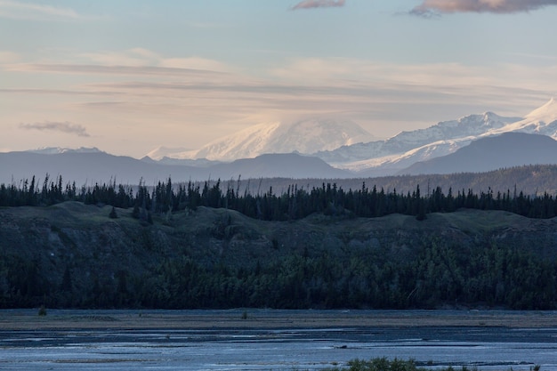 Montanhas pitorescas do Alasca no verão. Maciços cobertos de neve, geleiras e picos rochosos.