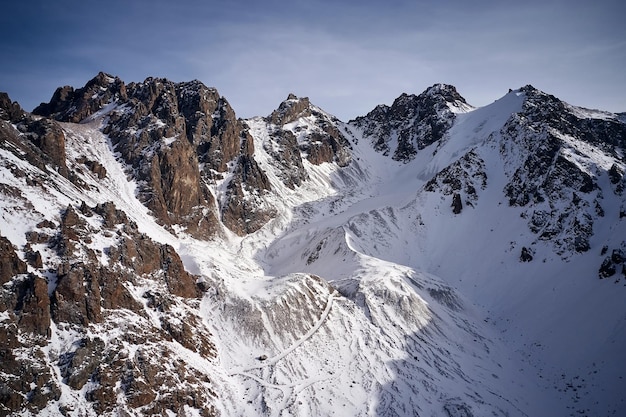 Montanhas rochosas de neve com céu azul no Cazaquistão