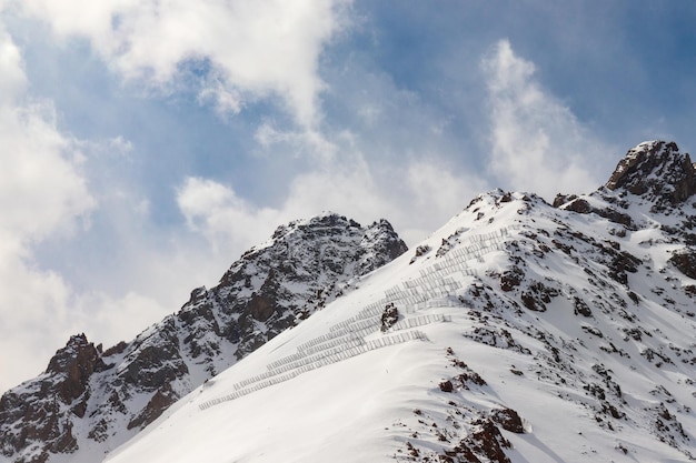Montanhas rochosas nevadas com barreiras de proteção contra avalanches