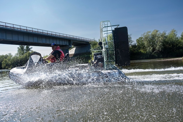 Montar a alta velocidad en un hidrodeslizador en el río en un día de verano con salpicaduras y olas