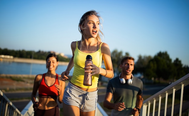 Montar amigos entrenamiento físico juntos al aire libre que viven activos y saludables