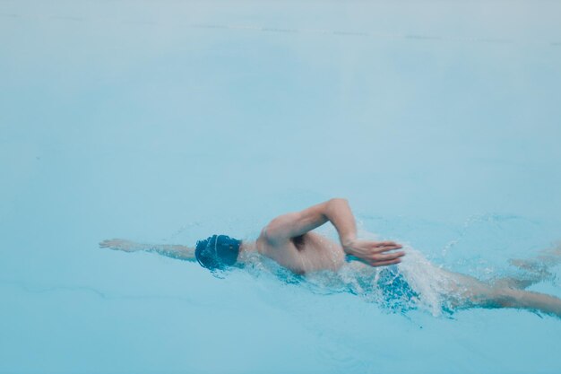 Montar nadador entrenamiento masculino natación rastreo en piscina abierta de invierno con niebla Concepto de salud de spa geotérmico al aire libre