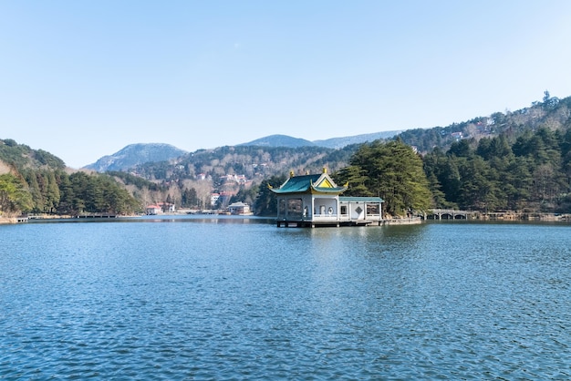 Monte a paisagem luxuriante do pavilhão tradicional no lago China