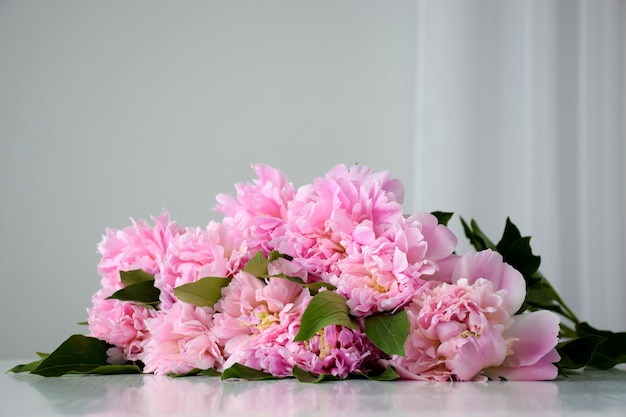 Monte de fresco corte lindas flores de peônia rosa em flor na mesa branca