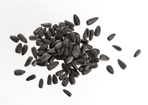 Monte de sementes de girassol pretas isoladas no branco