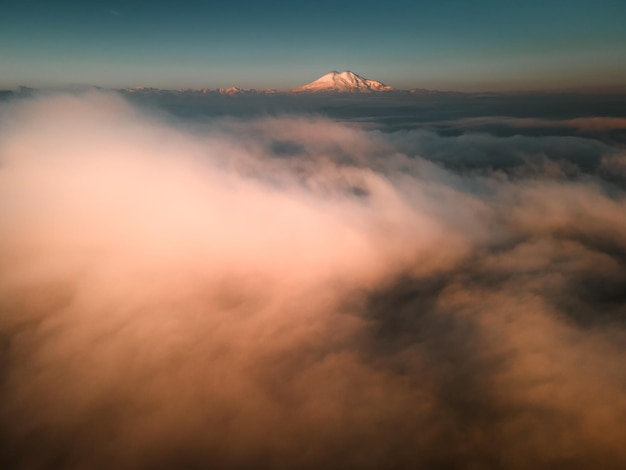 Monte Elbrus con nubes al amanecer brumoso Valle GilSu en el norte del Cáucaso Rusia