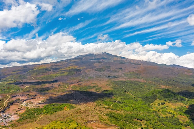 Foto monte etna en la isla de sicilia italia cuando hace buen tiempo con pintorescas nubes en la cima del volcán