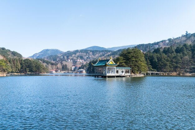 Monte el paisaje exuberante del pabellón tradicional en el lago China