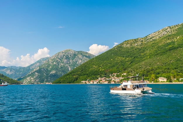 MONTENEGRO, KAMENARI - JUNI 04/2017: Touristen schwimmen in der Bucht von Boka Kotorska auf einem Motorkatamaran.