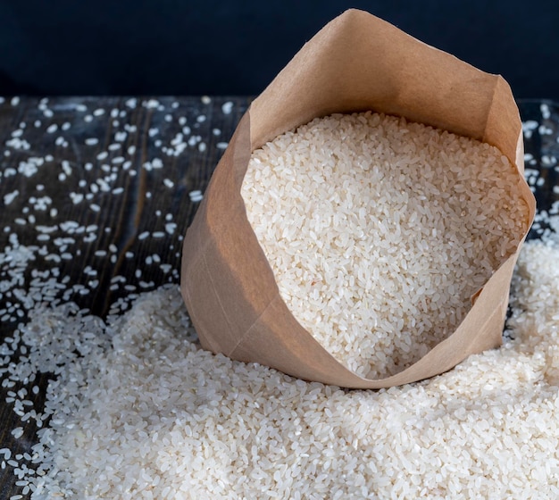 Un montón de arroz blanco en una bolsa de papel y sobre la mesa