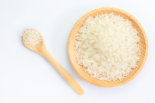 Montón de arroz crudo en un tazón de madera y una cuchara