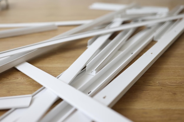 Un montón de bandejas de cables de plástico blanco en el piso de madera, reparación de cables eléctricos y casa