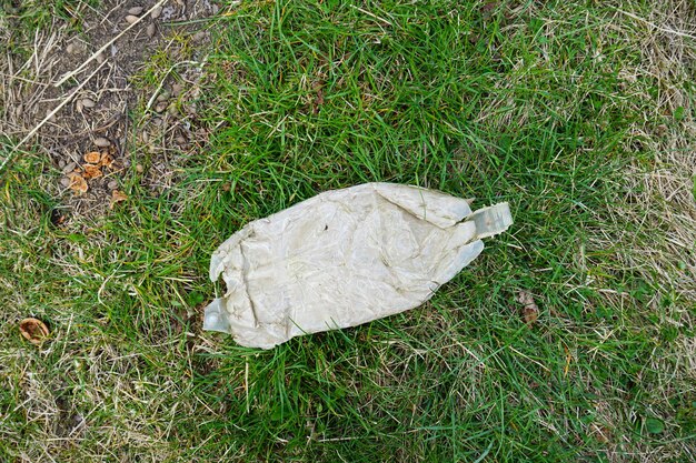 Montón de basura en el fondo de la vista superior de la hierba verde Concepto de ecología Botella de plástico