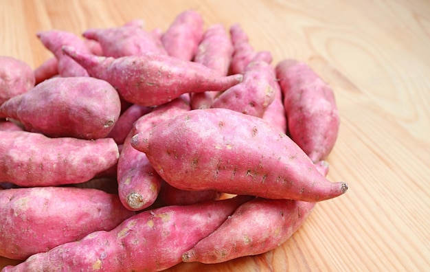 Montón de batatas crudas sobre fondo de madera