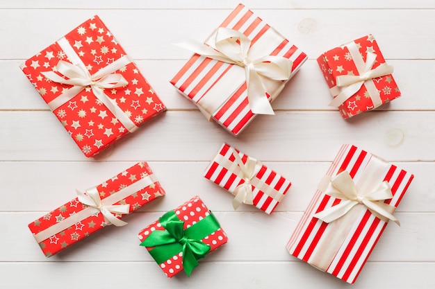 Un montón de cajas de regalo de Navidad en papel de colores decoradas en la mesa, vista superior de cerca. Muchos presentan regalo de año nuevo.