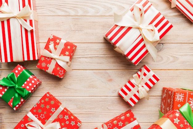 Un montón de cajas de regalo de Navidad en papel de colores decoradas en la mesa, vista superior de cerca. Muchos presentan regalo de año nuevo.