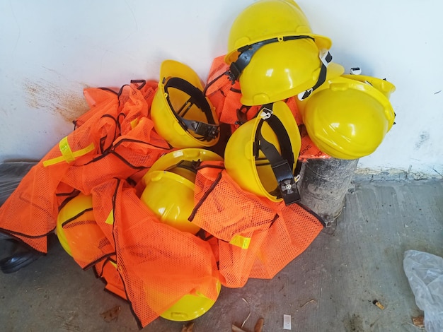 Un montón de cascos de construcción están en el suelo.