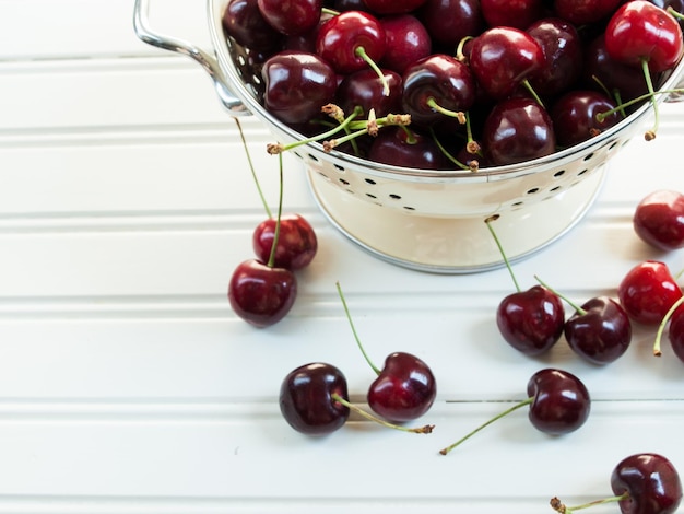 Montón de cerezas recién cogidas en un colador.