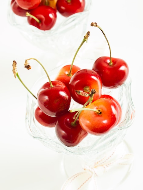 Montón de cerezas recién cogidas en platos de vidrio.