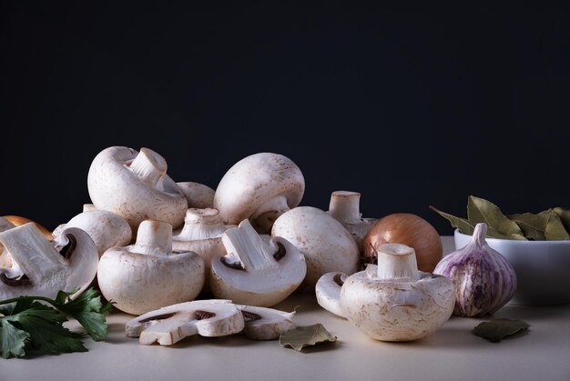 Un montón de champiñones frescos crudos enteros con otros ingredientes de cocina en la mesa o en el fondo Champiñones...