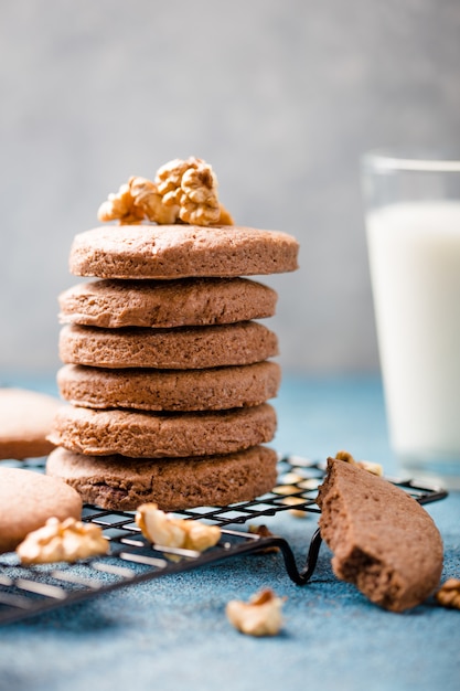 Montón de deliciosas galletas con chispas de chocolate en un tablero con botellas de leche