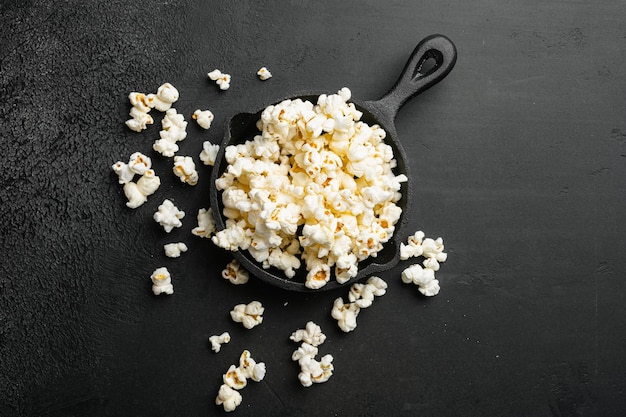 Montón de deliciosas palomitas de maíz sobre fondo de mesa de piedra oscura negra vista superior plana con espacio de copia para texto