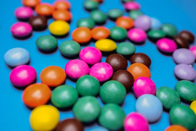 Un montón de dulces coloridos en una mesa azul