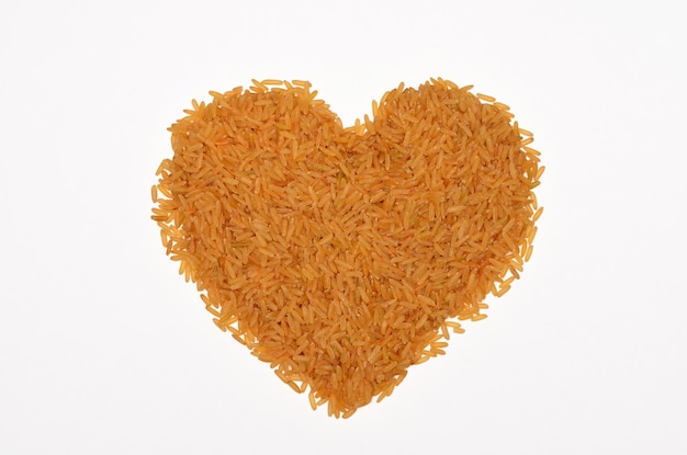 Montón en forma de corazón de arroz de bronce aislado sobre fondo blanco.