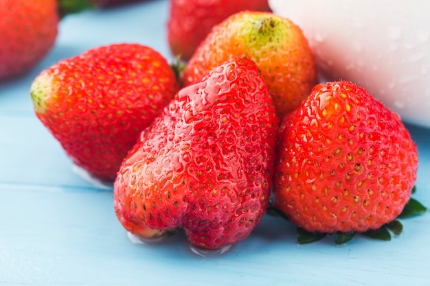 Montón de fresas frescas sobre fondo de tablero de madera