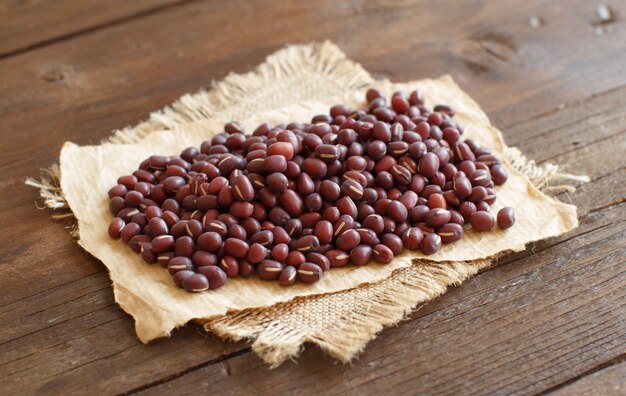 Un montón de frijoles azuki crudos sobre una mesa de madera