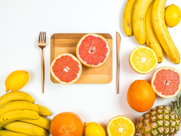 Foto un montón de fruta está sobre una mesa con un tenedor y un plato cortado por la mitad