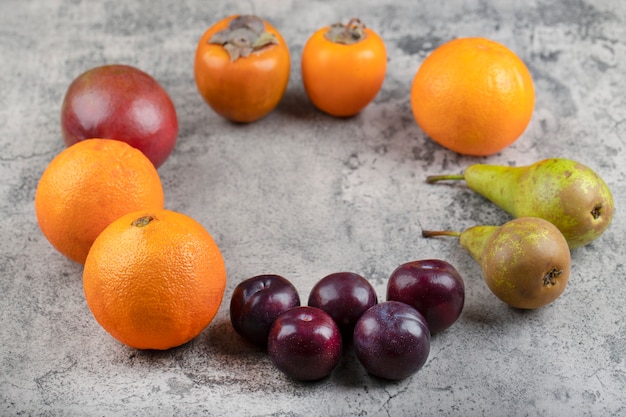 Montón de frutas frescas maduras colocadas sobre la superficie de la piedra