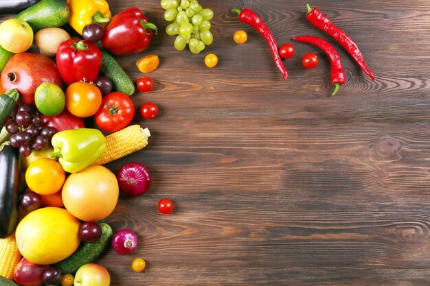 Un montón de frutas y verduras sobre un fondo de madera