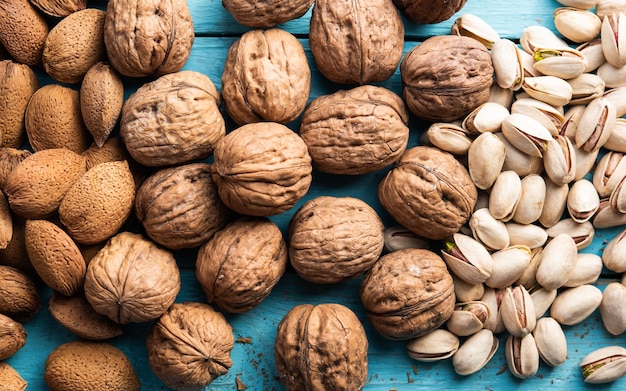 Un montón de frutos secos pistachos orgánicos almendras nueces recién cosechadas en una madera en un mercado