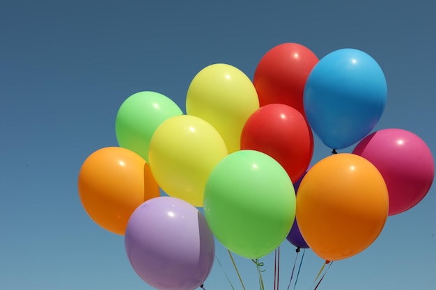 Montón de globos de colores contra el cielo azul