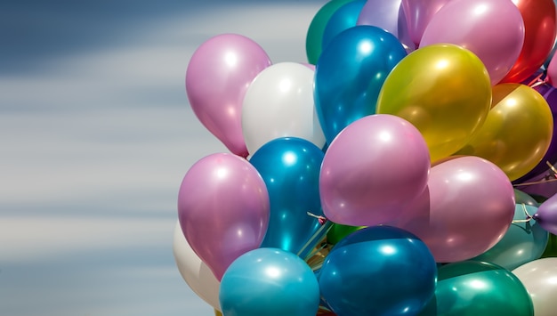 Montón de globos de colores sobre un fondo de cielo azul