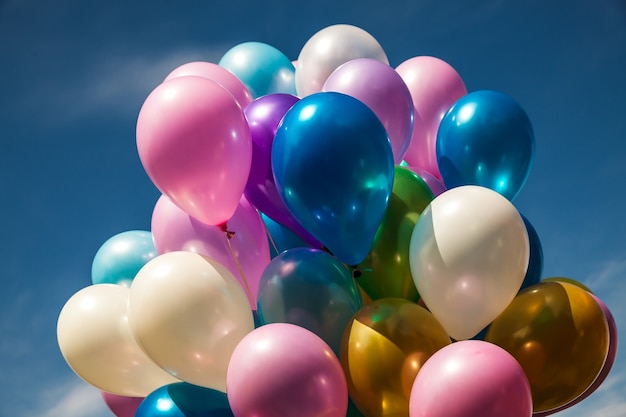 Montón de globos de colores sobre un fondo de cielo azul