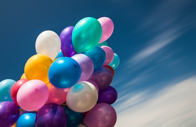 Montón de globos de colores sobre un fondo de cielo azul