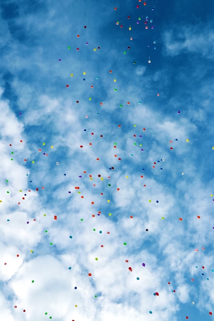 Un montón de globos multicolores en el cielo azul