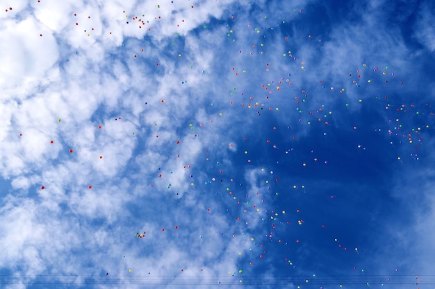 Un montón de globos multicolores en el cielo azul