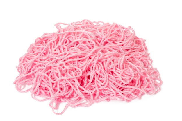 Montón de un hilo de lana enredado de color rosa.