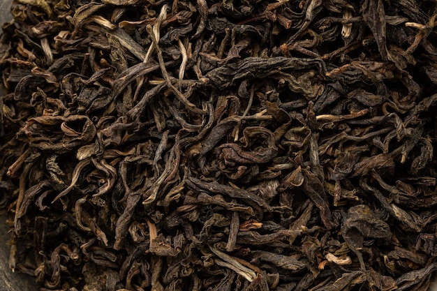 Montón de hojas de té secas. Té negro seco. Fondo texturizado de hojas secas de té negro aromático con canela