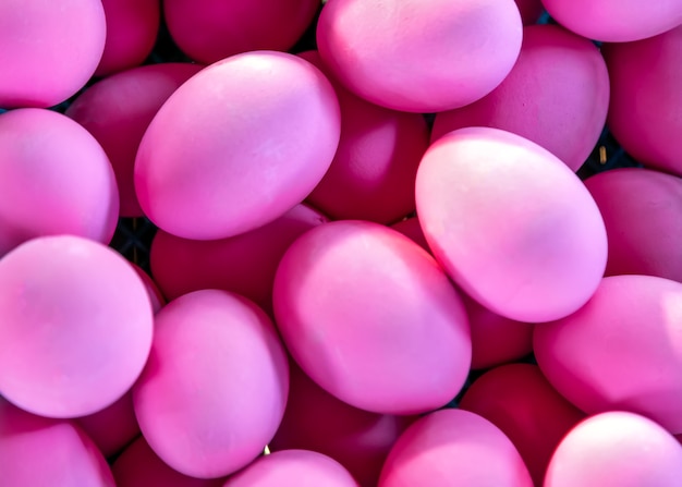 Un montón de huevos rosados preparados y pintados para la textura de fondo rosa de Pascua