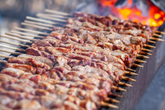 Un montón de jugosas brochetas de carne seguidas a la parrilla Piezas de carne ensartadas en brochetas de madera a la parrilla