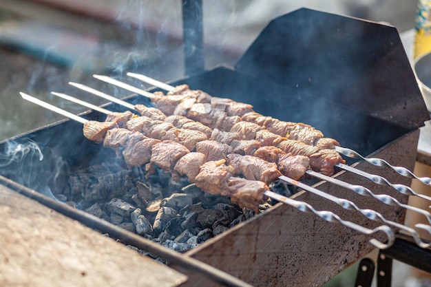 Un montón de jugosas brochetas de carne seguidas a la parrilla Piezas de carne ensartadas en brochetas de metal a la parrilla