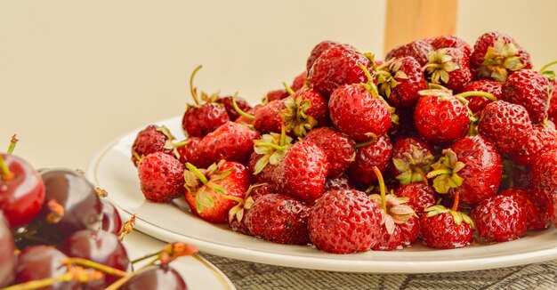 Un montón de jugosas fresas maduras en un recipiente blanco, cosecha de bayas de verano, fondo de alimentos.