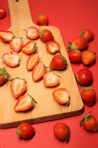 Un montón de jugosas fresas rojas sobre un fondo rojo en pantalla completa