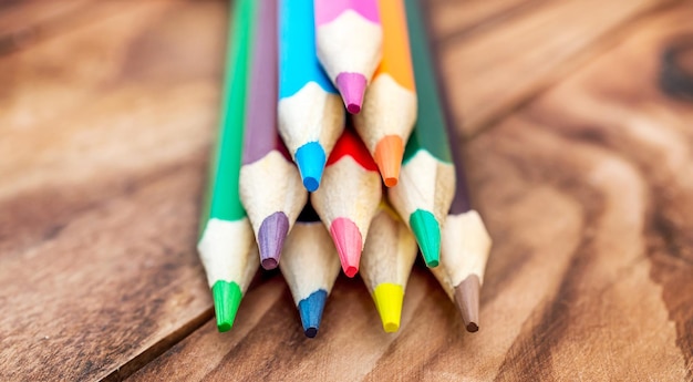 Montón de lápices de colores sobre el fondo de madera Cerrar