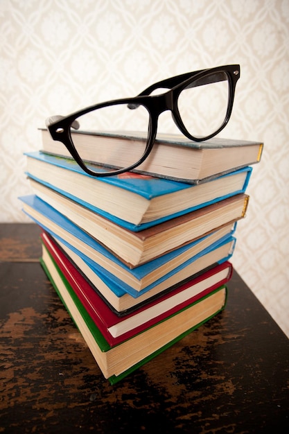 Un montón de libros para estudiar y gafas negras.